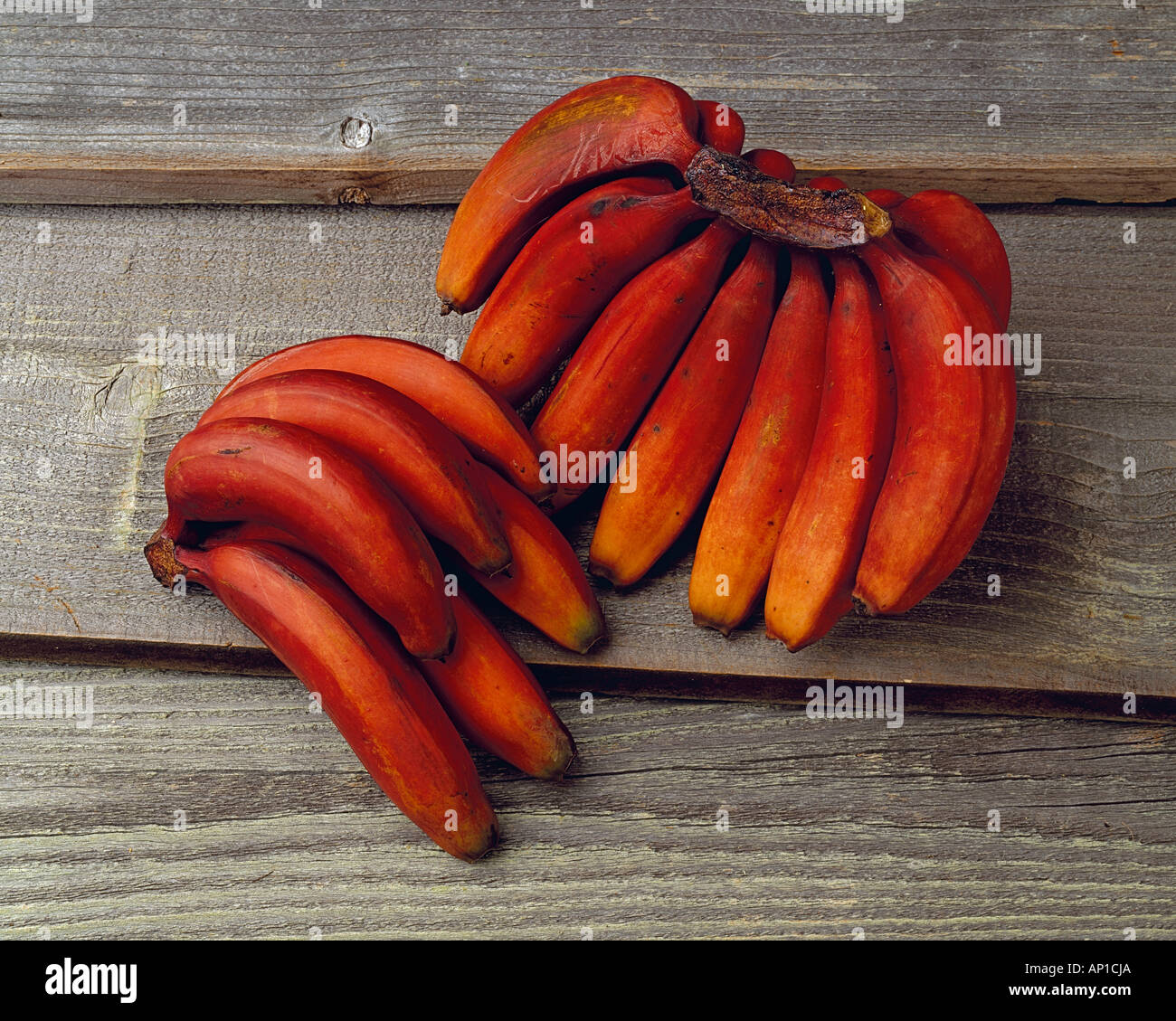 Agriculture - Red bananas on a barnwood surface, in studio. Stock Photo