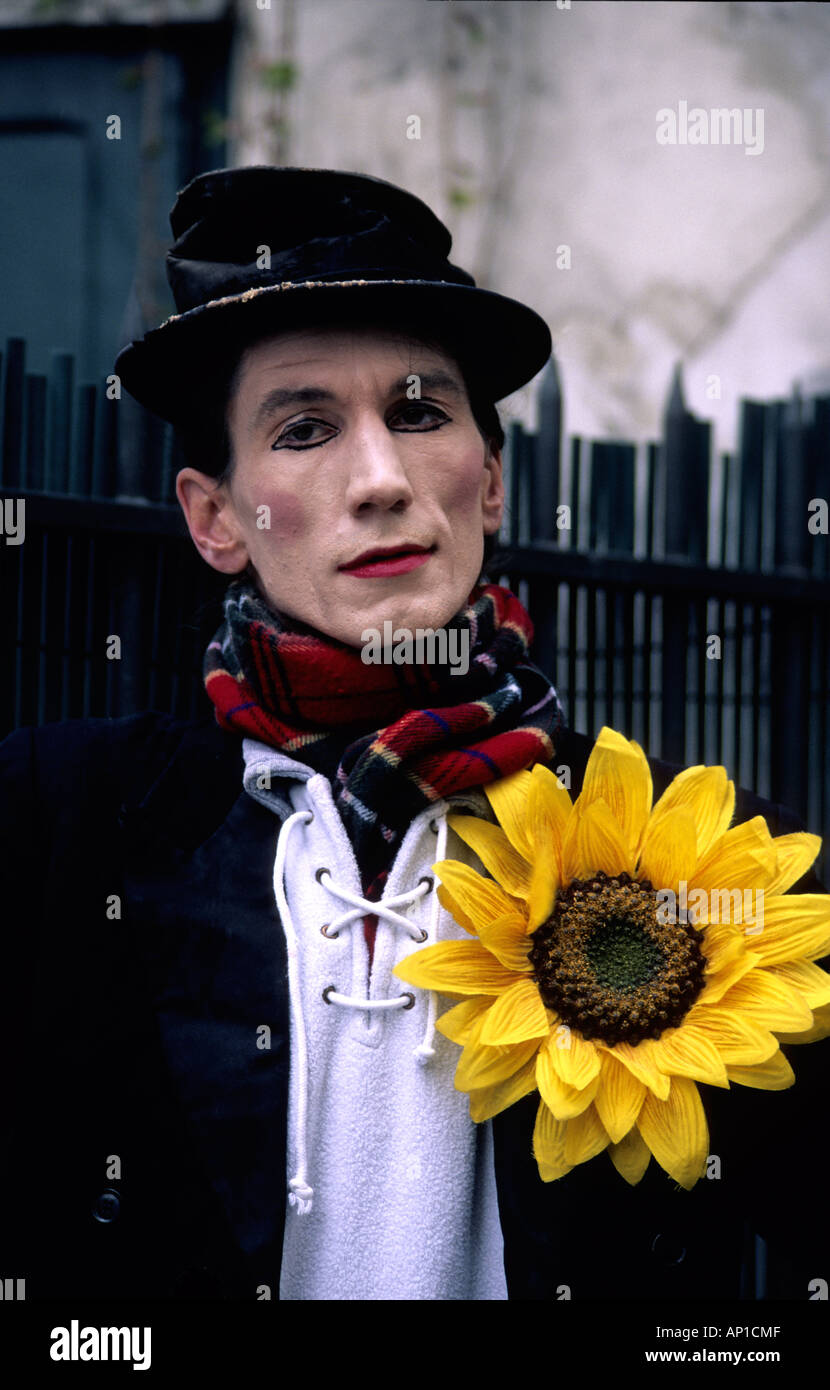 Parisian street white face mime artist with outsized yellow sunflower buttonhole Stock Photo