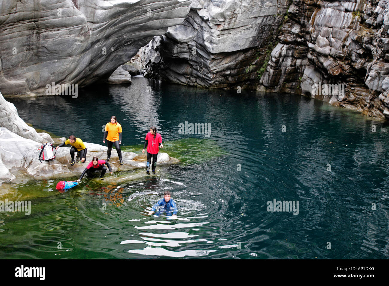 A group of people swims, through the Maggia Canyon, Valle Maggia, Tessin, South Switzerland Stock Photo