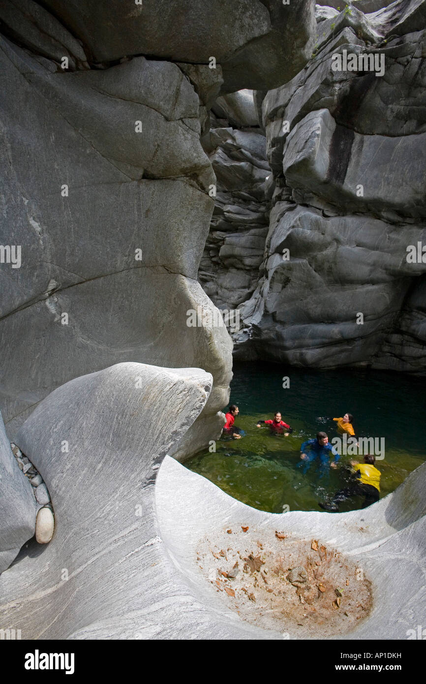 A group of people swims through the Maggia Canyon, Valle Maggia, Ticino, South Switzerland, Switzerland Stock Photo