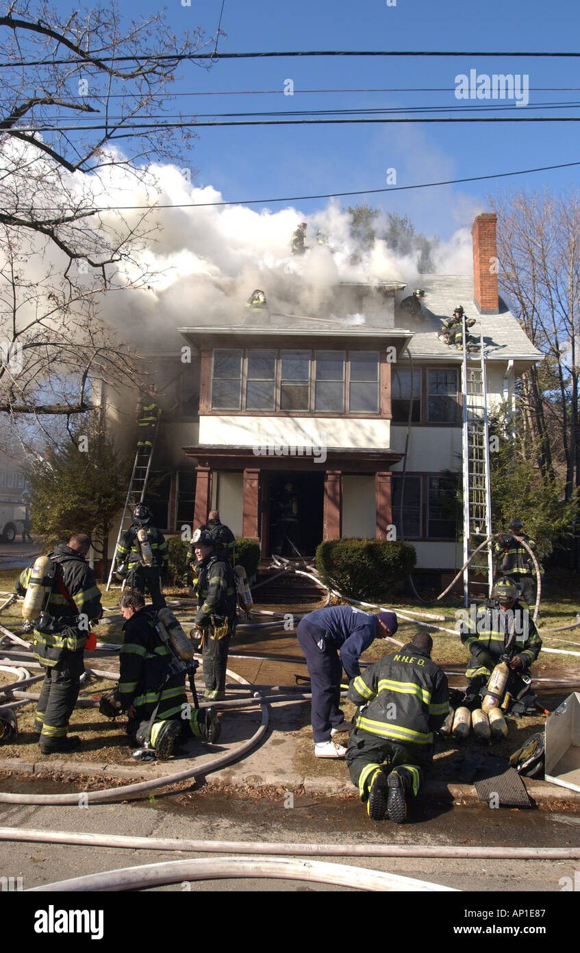 Firefighters change oxygen tanks as the battle a large house fire in