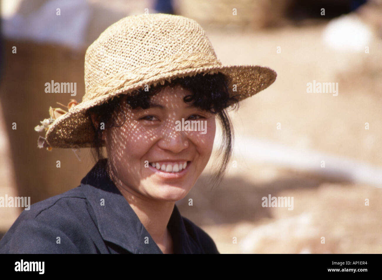 Pretty smiling local woman wearing a straw hat hi-res stock photography ...