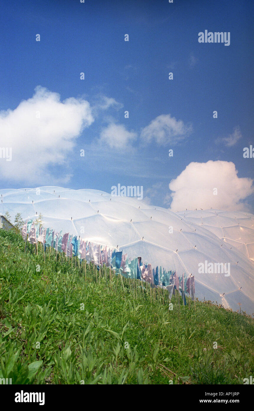 Colourful prayer flags display in front of a biodome at the Eden Project, Cornwall Stock Photo