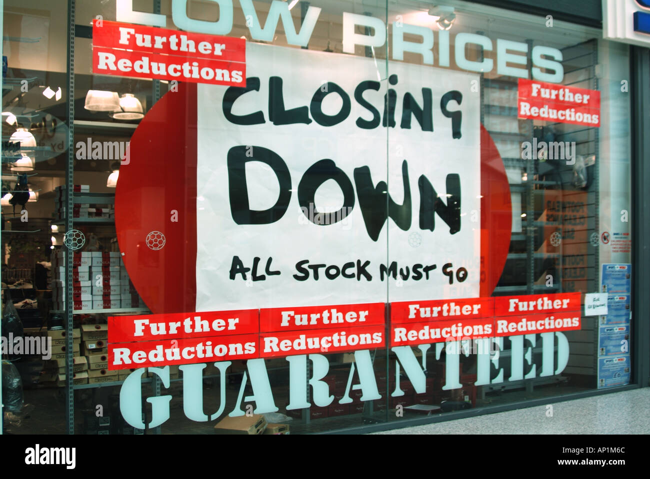 Big closing down "all stock must go" signs in sports footwear shop