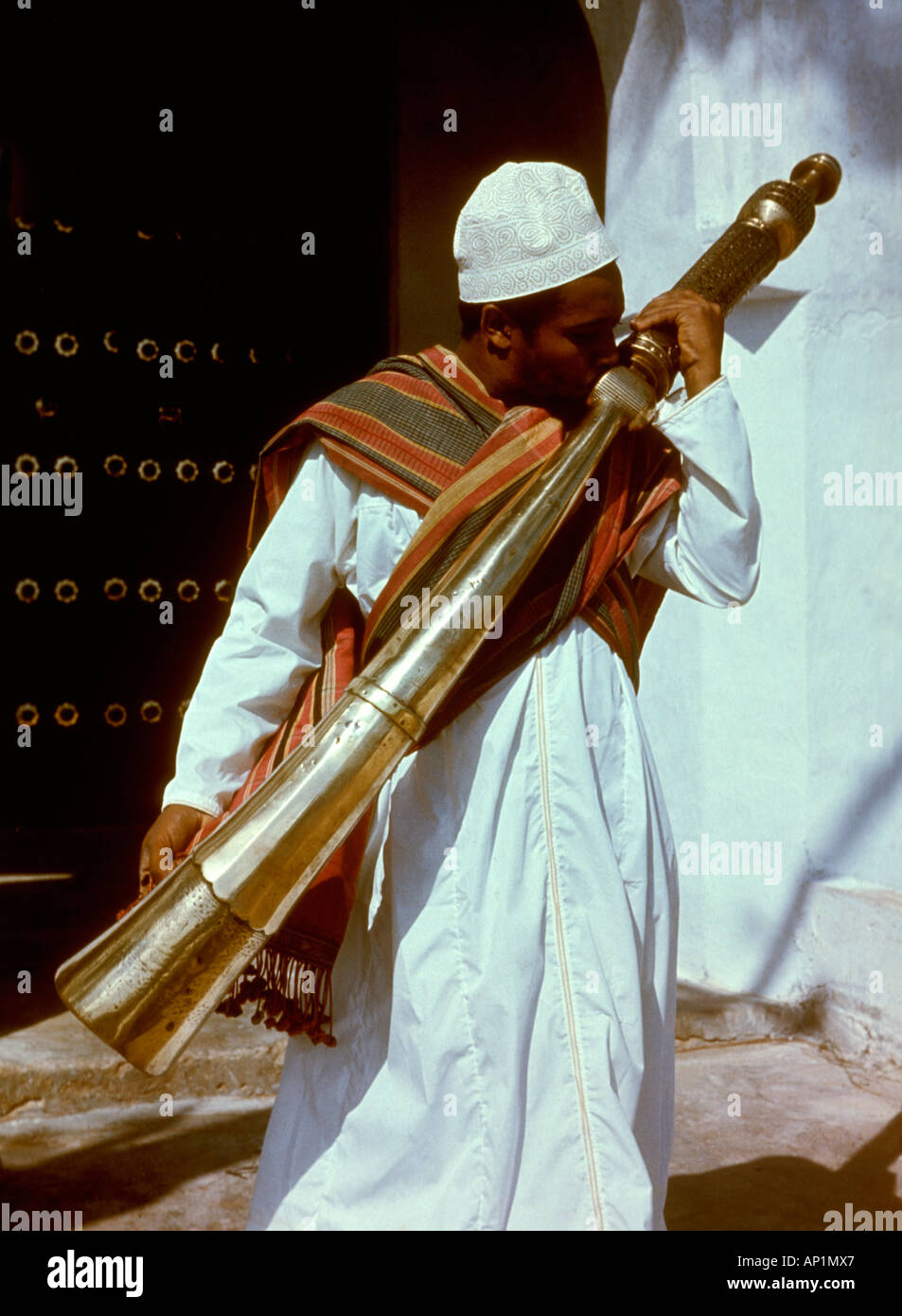 A Muslim man playing a SIWA or side blown horn Lamu island Kenya coast East Africa Stock Photo