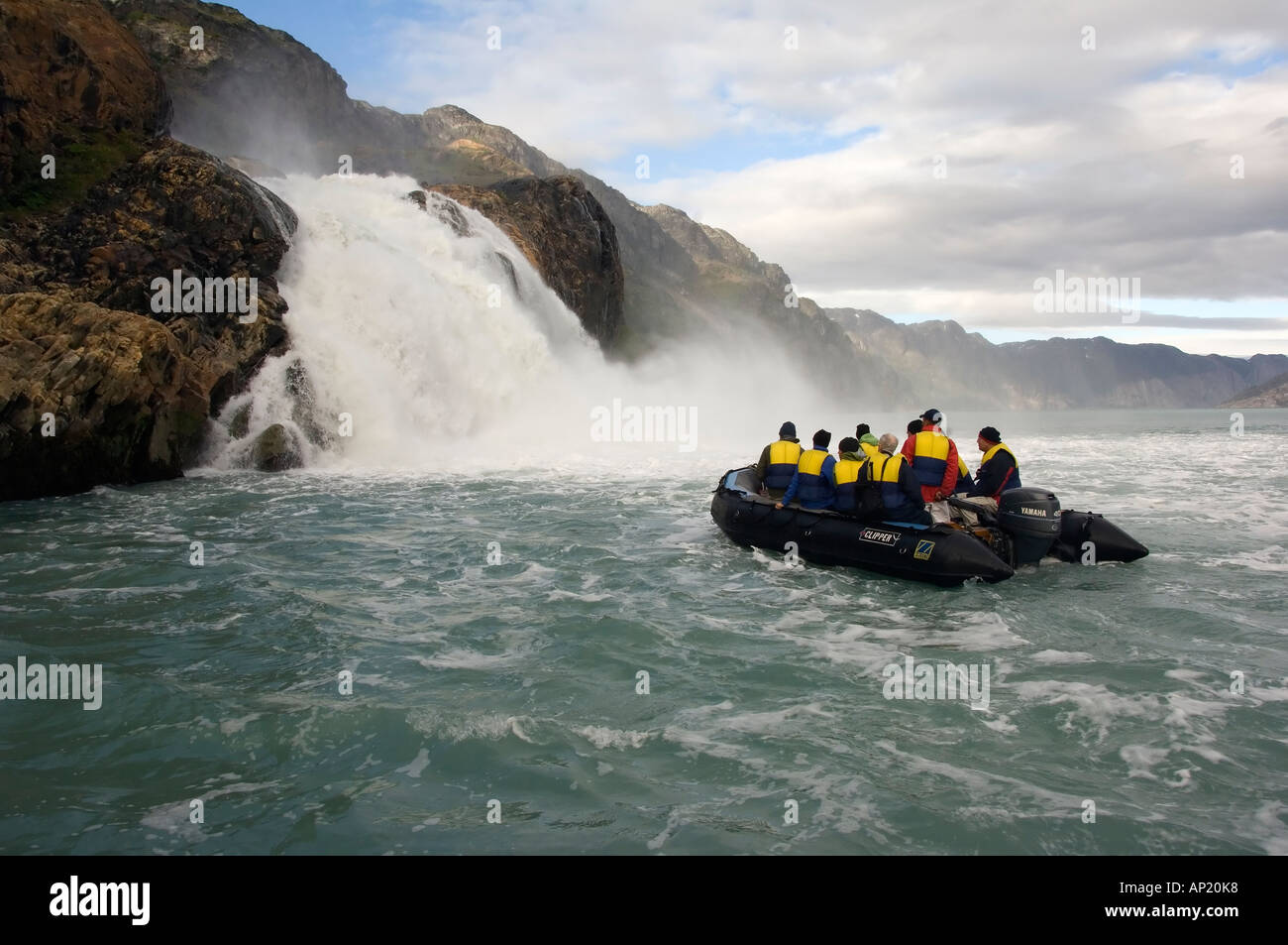 Zodiac with tourists approaching a waterfall Arsuk Fjord Greenland Denmark Stock Photo