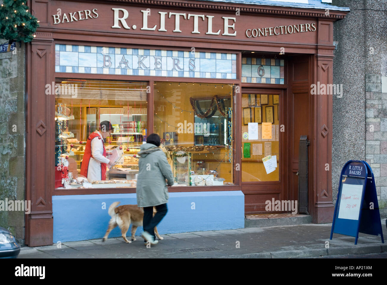 Moffat bakers shop front with shopper on the small town of Moffats High Street Dumfries and Galloway Scotland UK Stock Photo