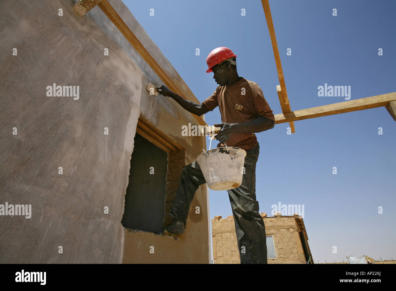 Sudanese labourer paints hospital building of an humanitarian organization in the refugee camp in Bahai Stock Photo
