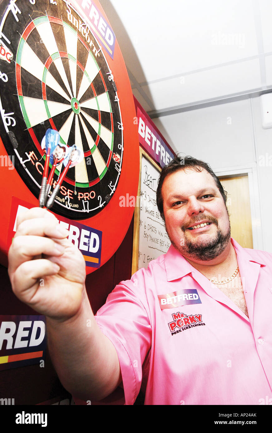 Professional dart player Peter Manley at the dart board holding darts ready  to play exhibition match at Betfred bookmakers shop,Preston,Lancashire,UK  Stock Photo - Alamy