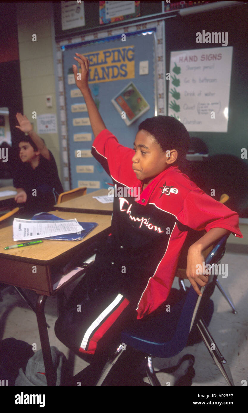 African American boy raising his hand in an Elementary school classroom ...