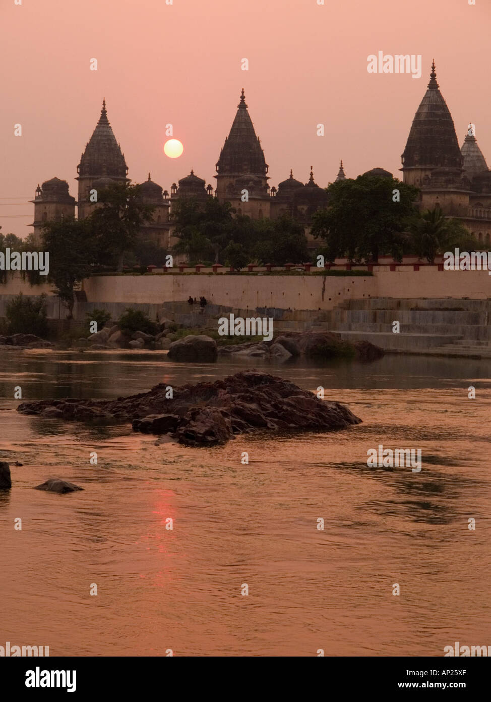 Orrchha Madhya Pradesh India. Betwa River at sunset with sun setting behind domes and spires of Chhatris Bundela Stock Photo