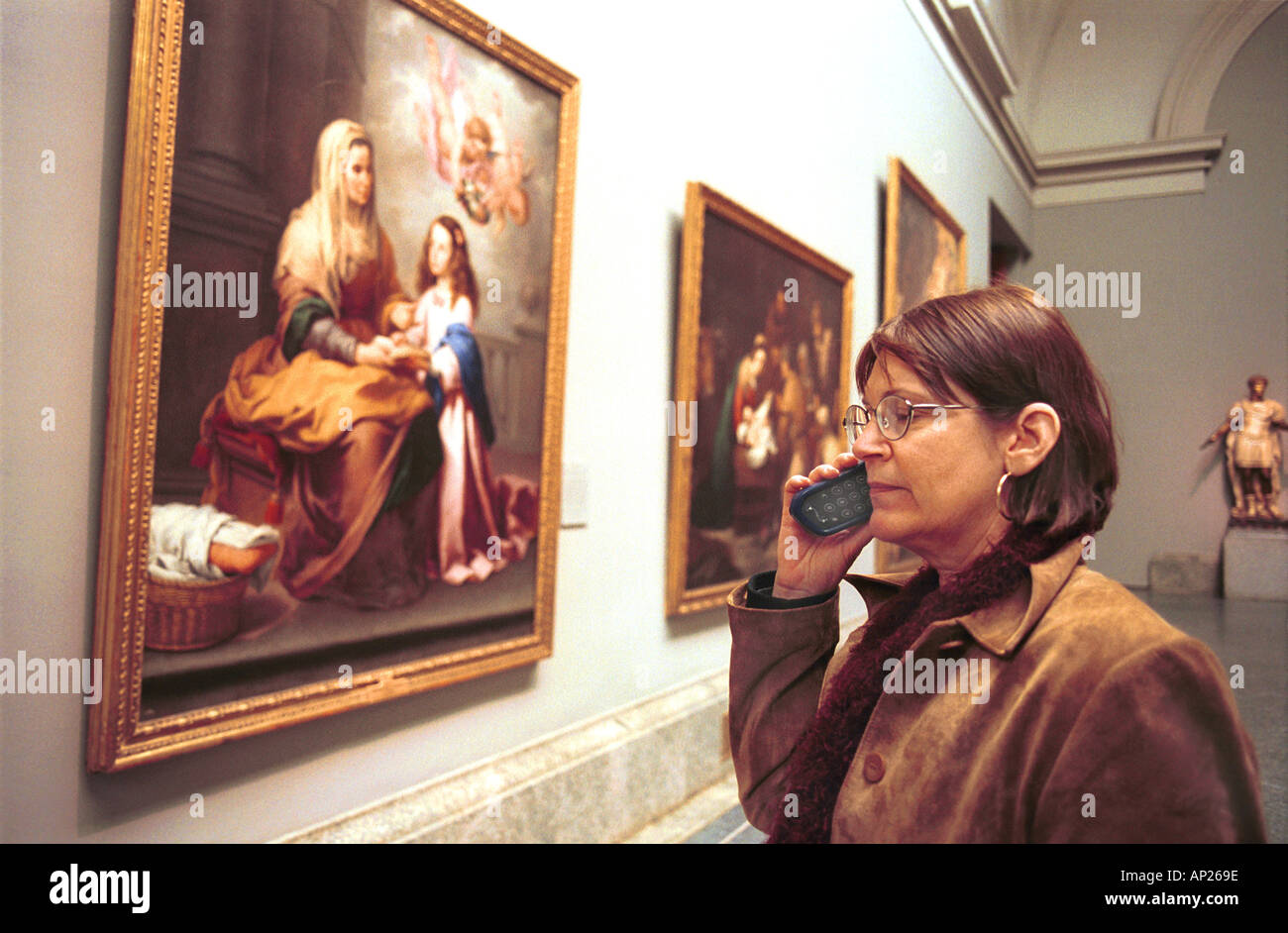 Female tourist listening to a translator at the Prado art museum in Madrid Spain  Stock Photo