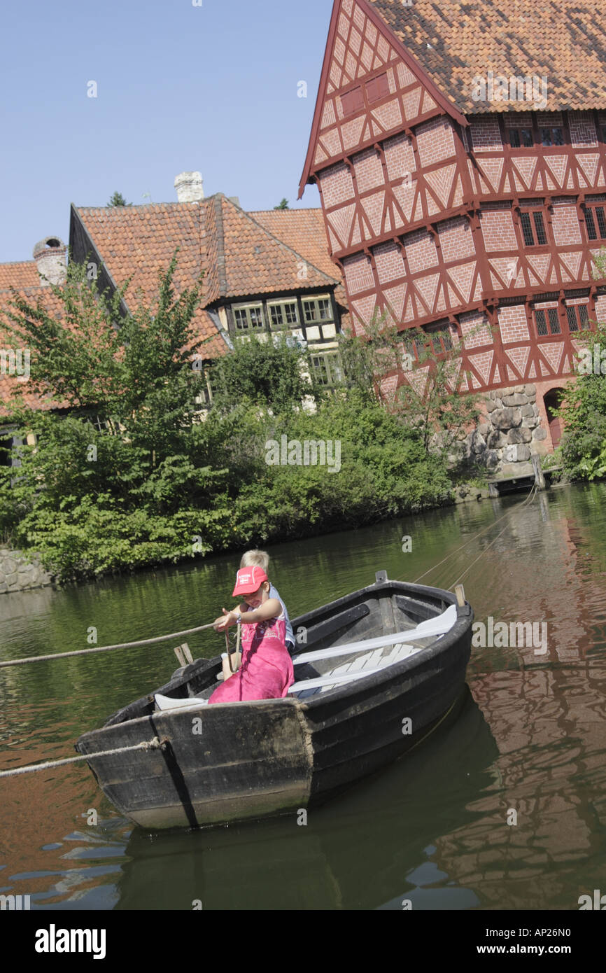 Children pulling themselves across the pond in a boat at the Old Town Museum Den Gamle By, Arhus Denmark Stock Photo