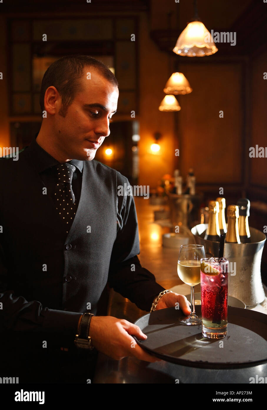 Bar tender carring a tray of drinks from the bar Stock Photo
