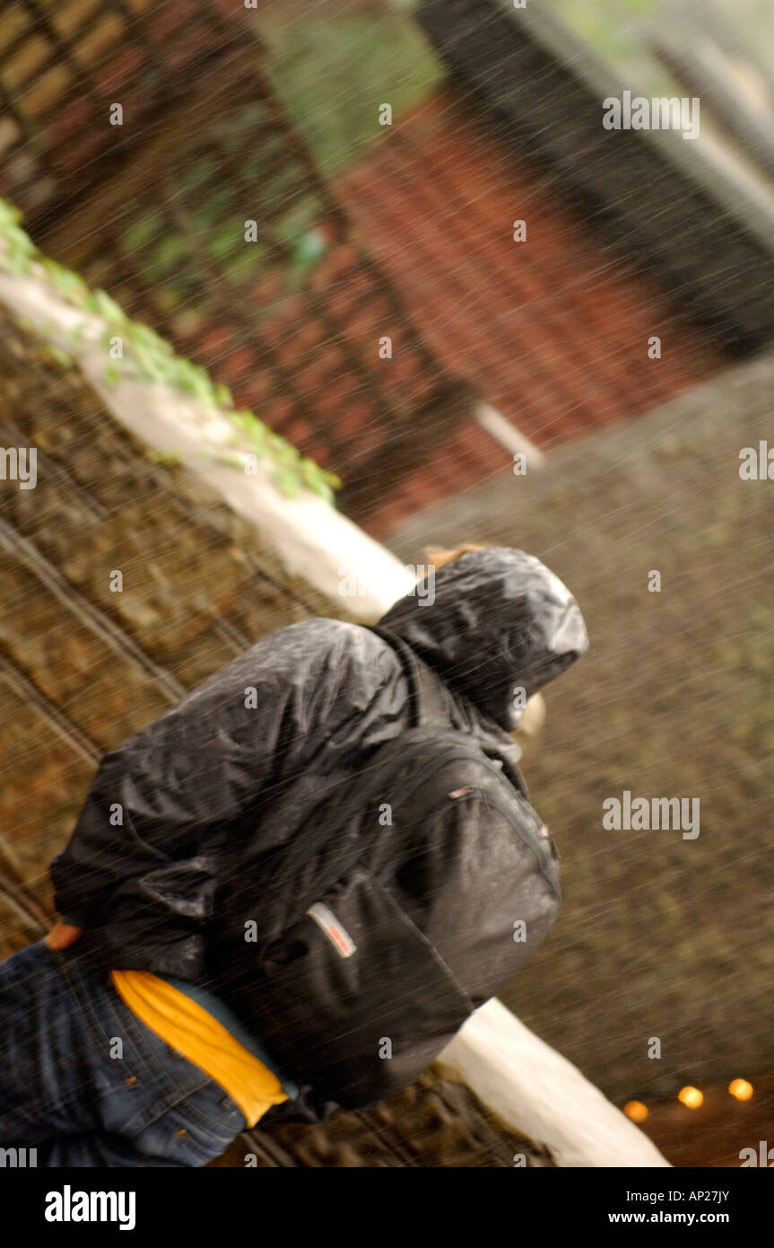 man walking in the rain wearing a waterproof jacket and rucksack with