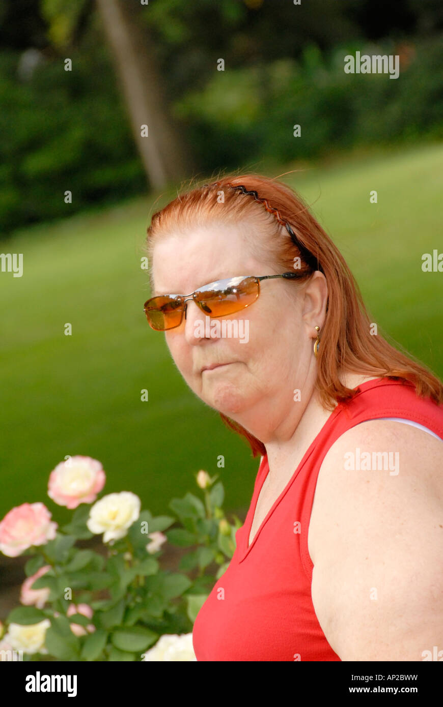Woman with sunglasses in a rose garden Stock Photo Alamy