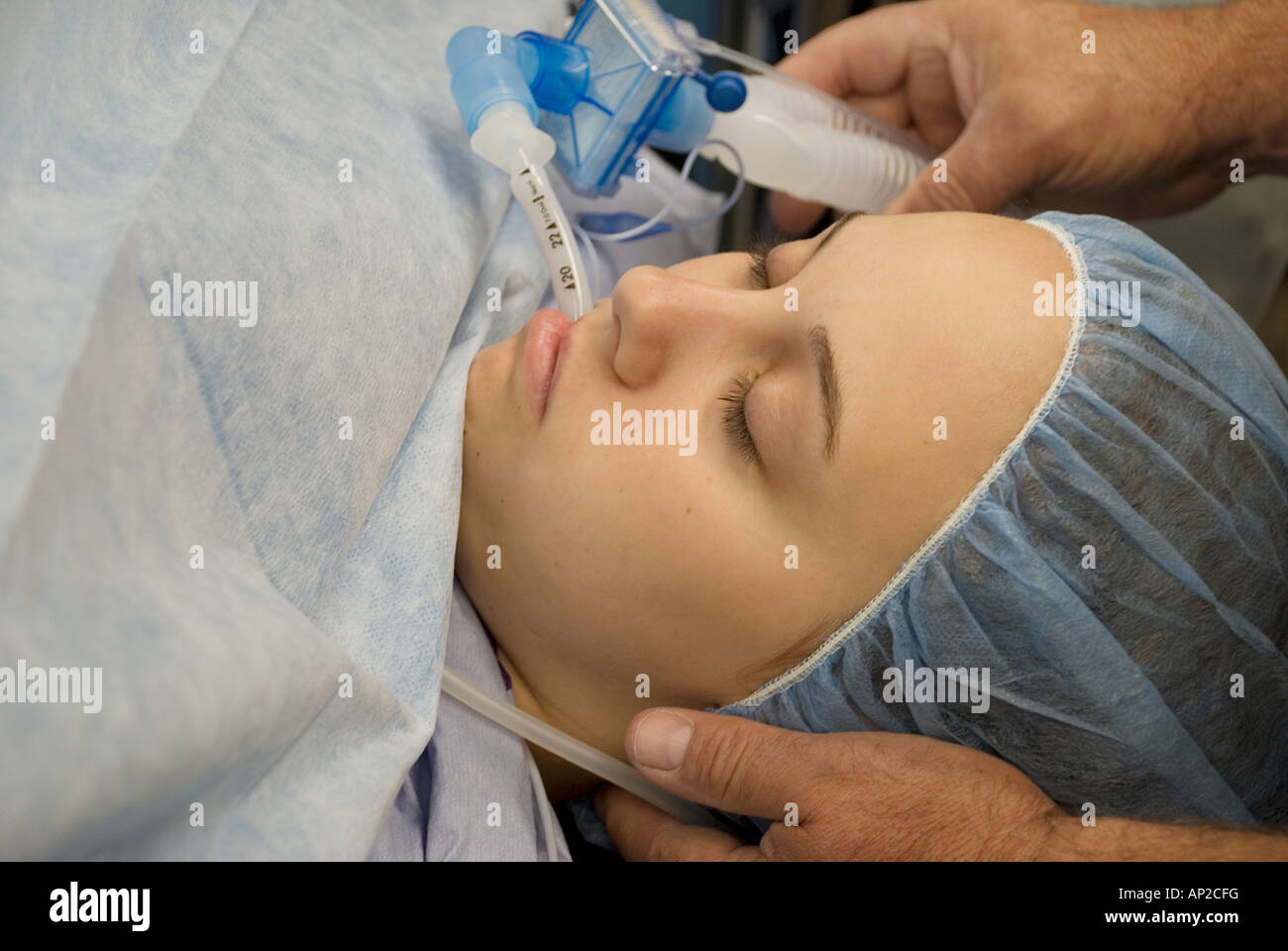 Female teenage patient under anesthesia during surgical procedure Stock Photo