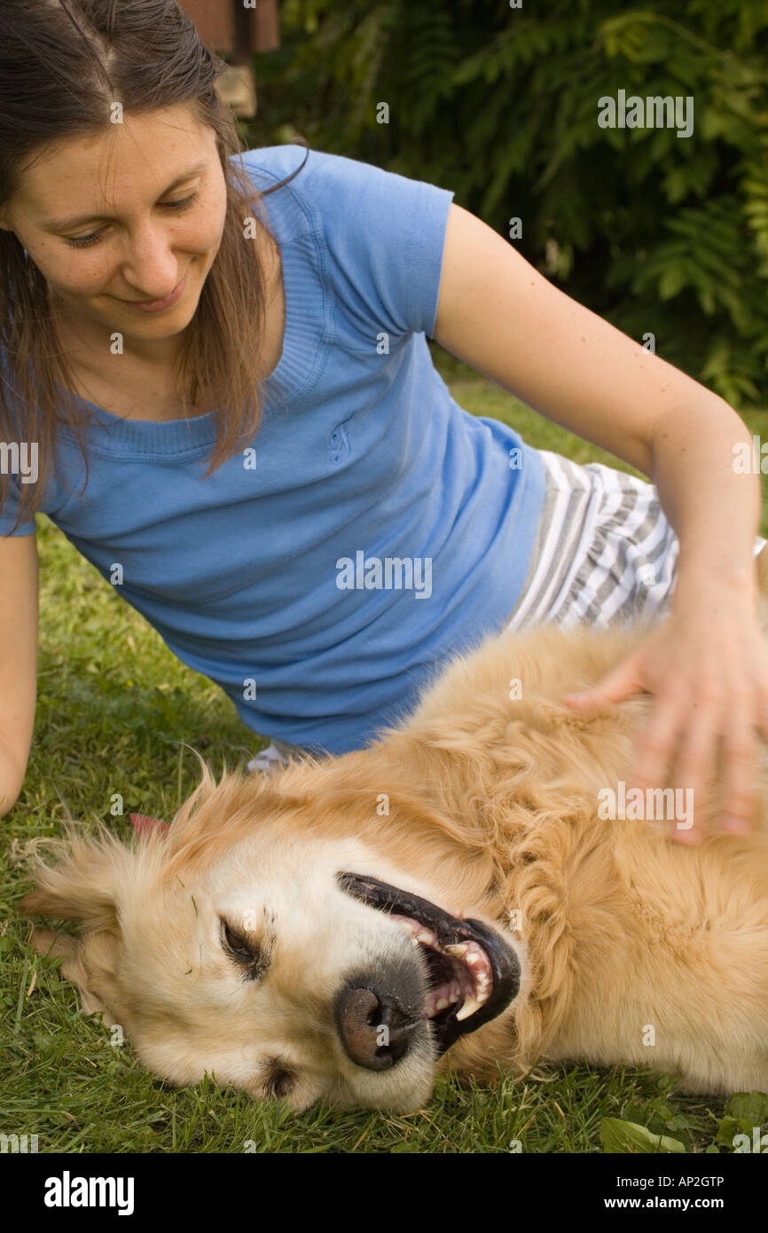 Girl petting golden retriever Slovenia Stock Photo - Alamy