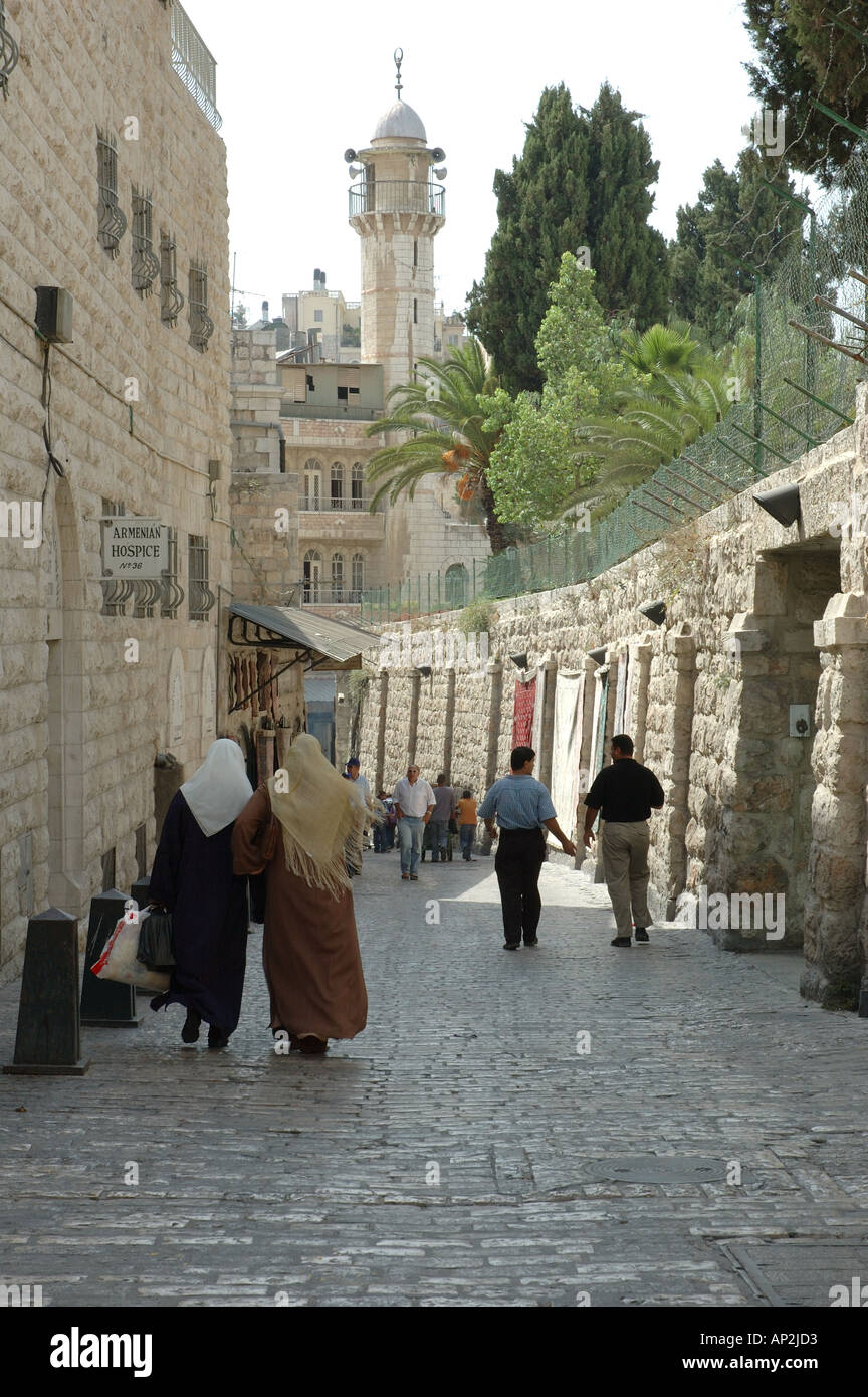 Two Palestinian women walk past the Armenian Hospice in the old city of Jerusalem Israel Stock Photo