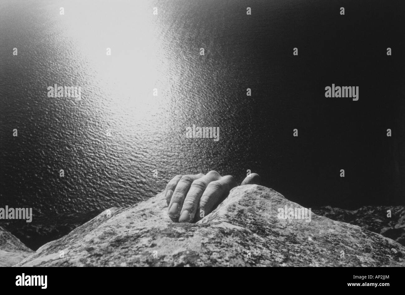 Hand of a man freeclimbing, climbing a rock face above the sea, Rock ...