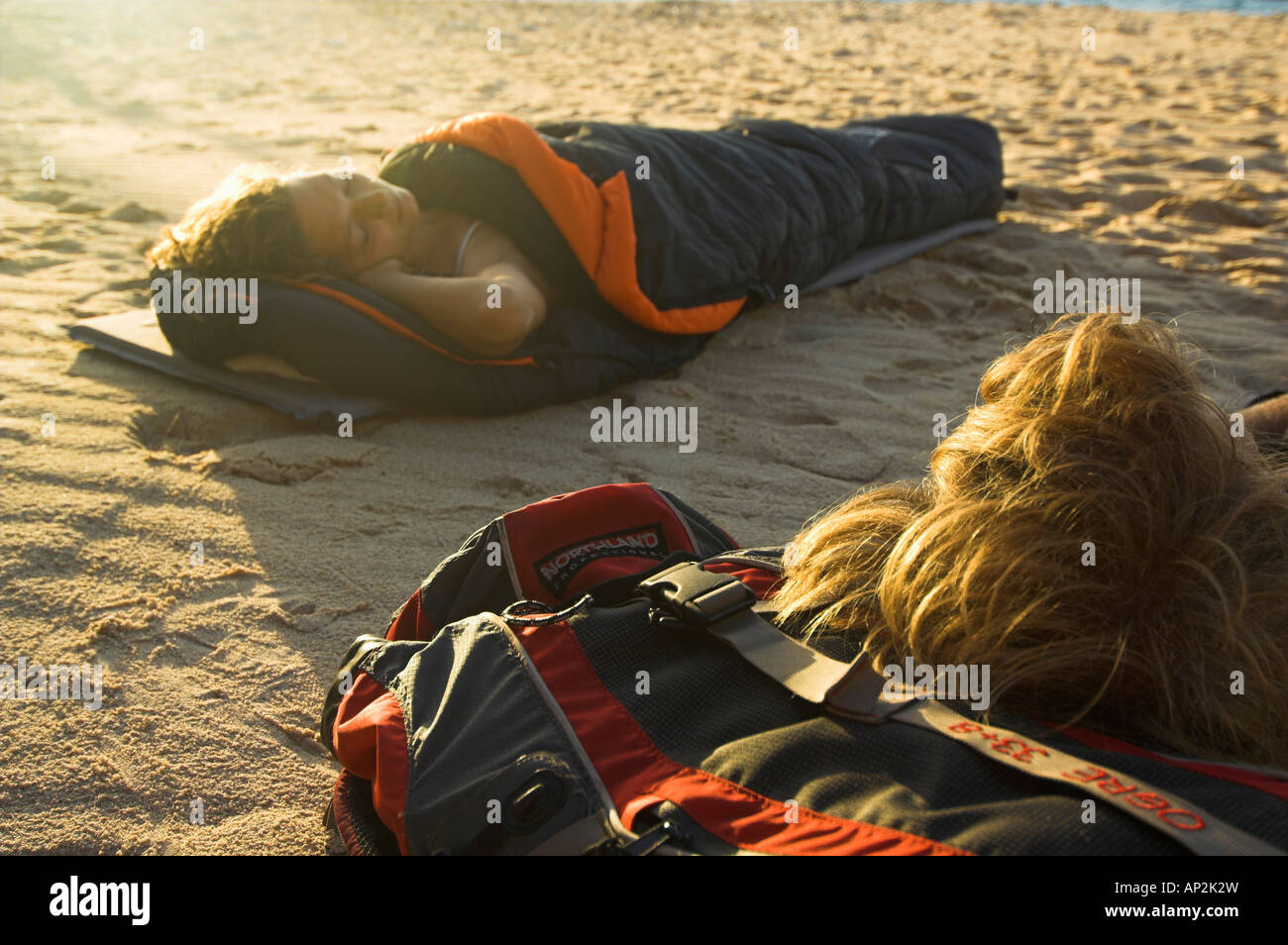 Young couple in sleeping bags at the beach Stock Photo