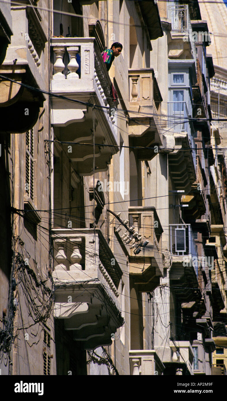 Boy on balcony in street of balconies Valletta Malta Europe Stock Photo