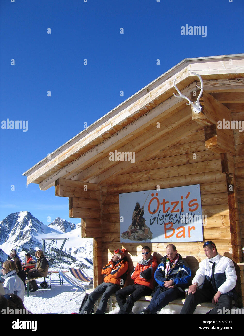 Four people sitting outside an alpine hut, Oetzis Gletscherbar, Schnalstal, South Tyrol, Italy Stock Photo