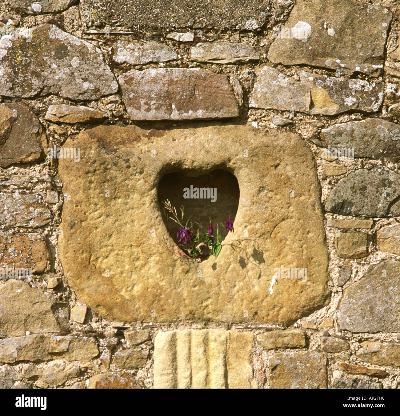 Heart shaped niche with flowers in stone wall Stock Photo Alamy