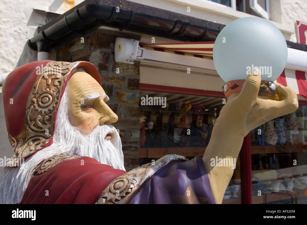 A plastic figure of the famous wizard Merlin holding an orb outside a