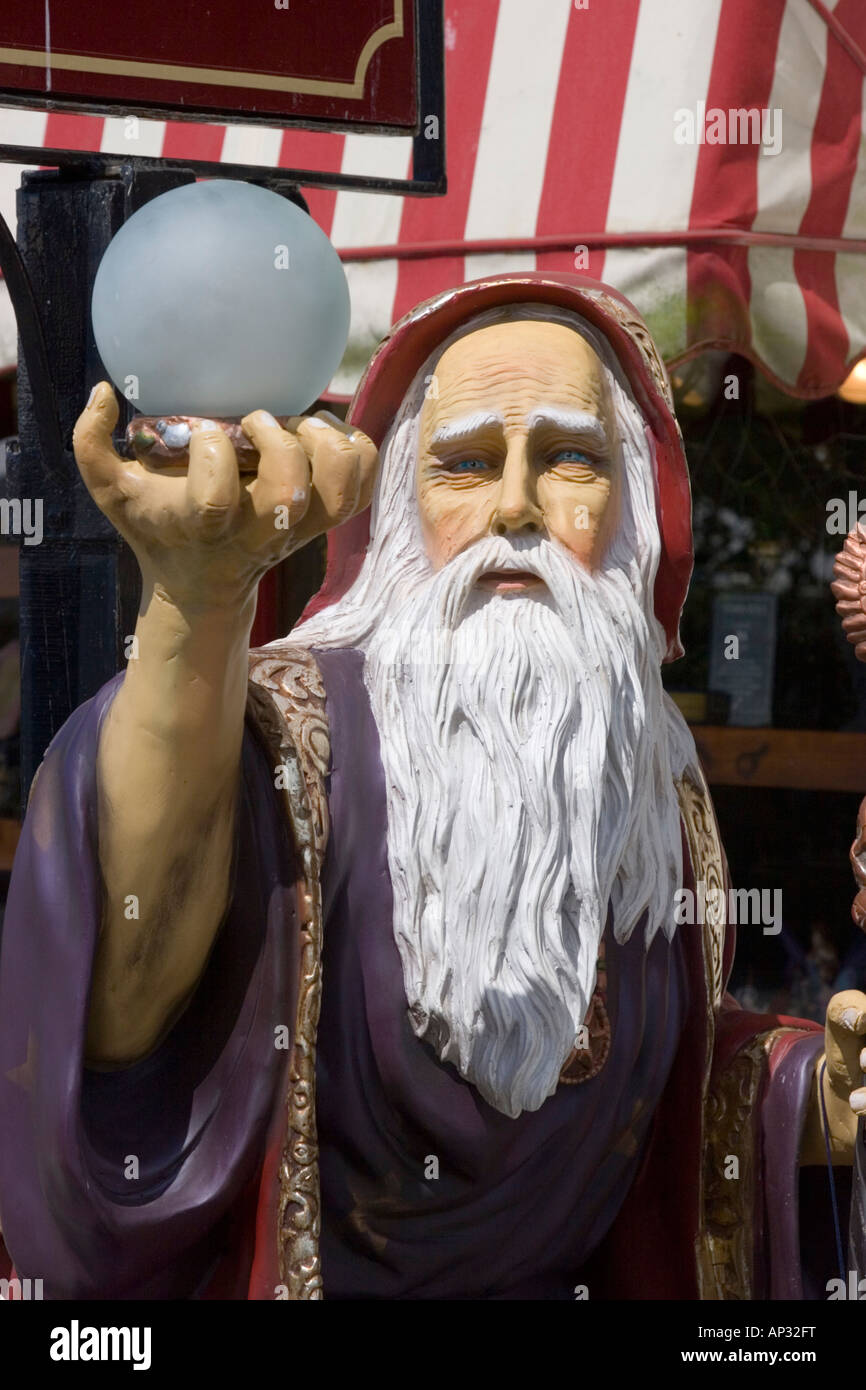A plastic figure of the famous wizard Merlin holding an orb outside a