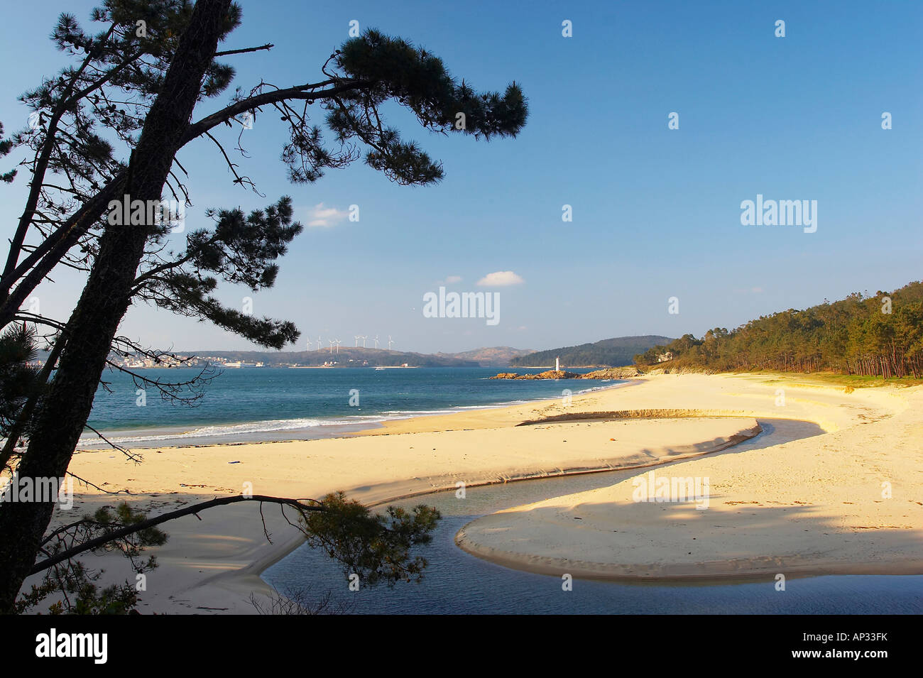 Landscape and beach with wind turbiones in the distance, bay near Leis, Ría de Camarinas, Costa da Morte, Galicia, Spain Stock Photo
