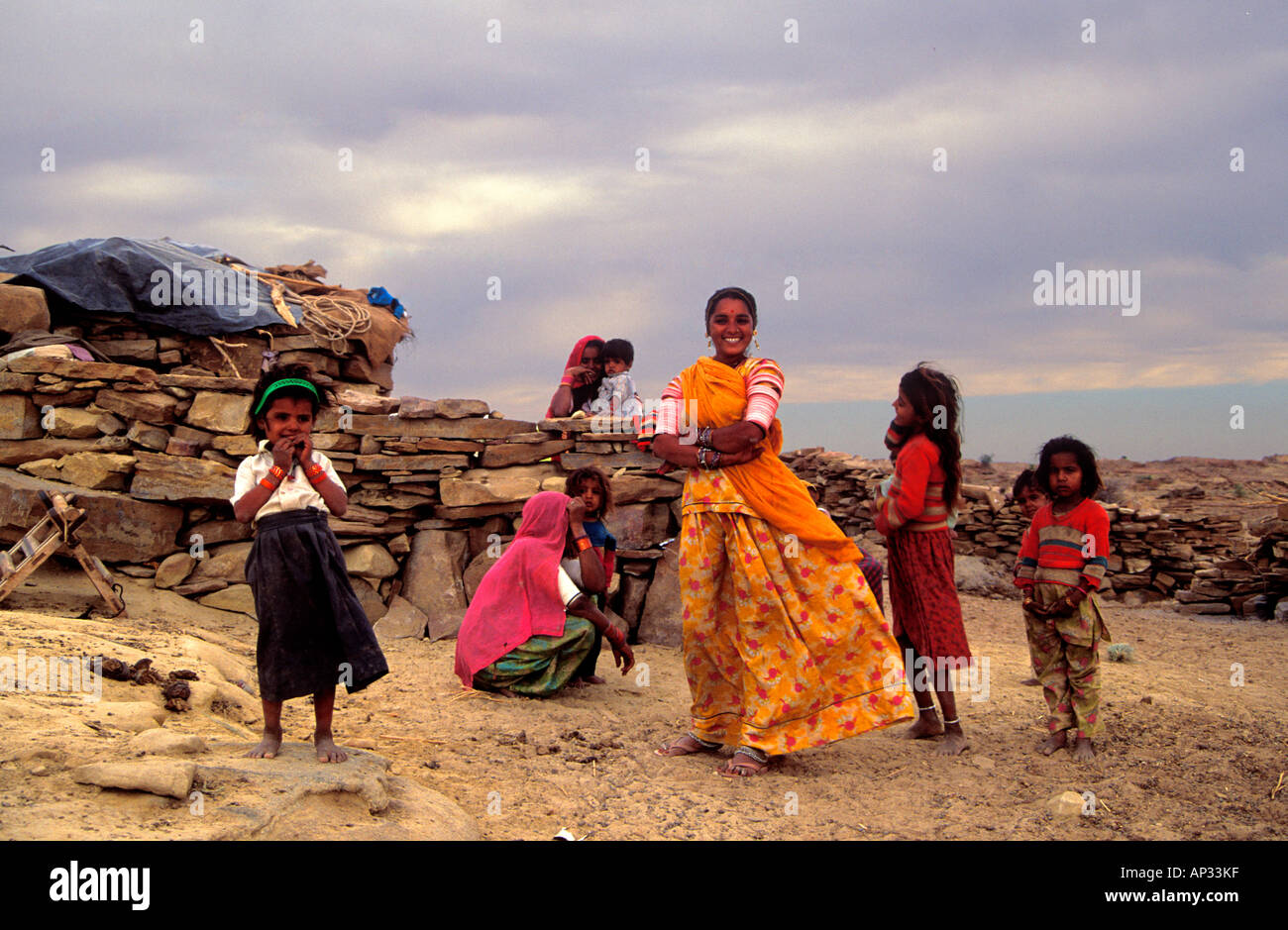 Nomadic Indian family gathered outside their makeshift home in the desert, Jaisalmer, Rajasthan, India Stock Photo