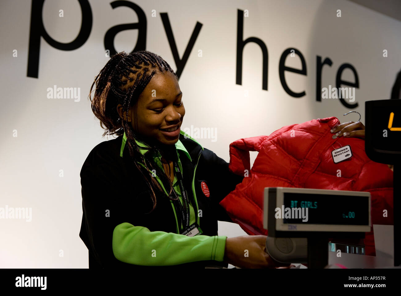 Shop assistant at checkout in ASDA store, Tottenham, north London Stock Photo