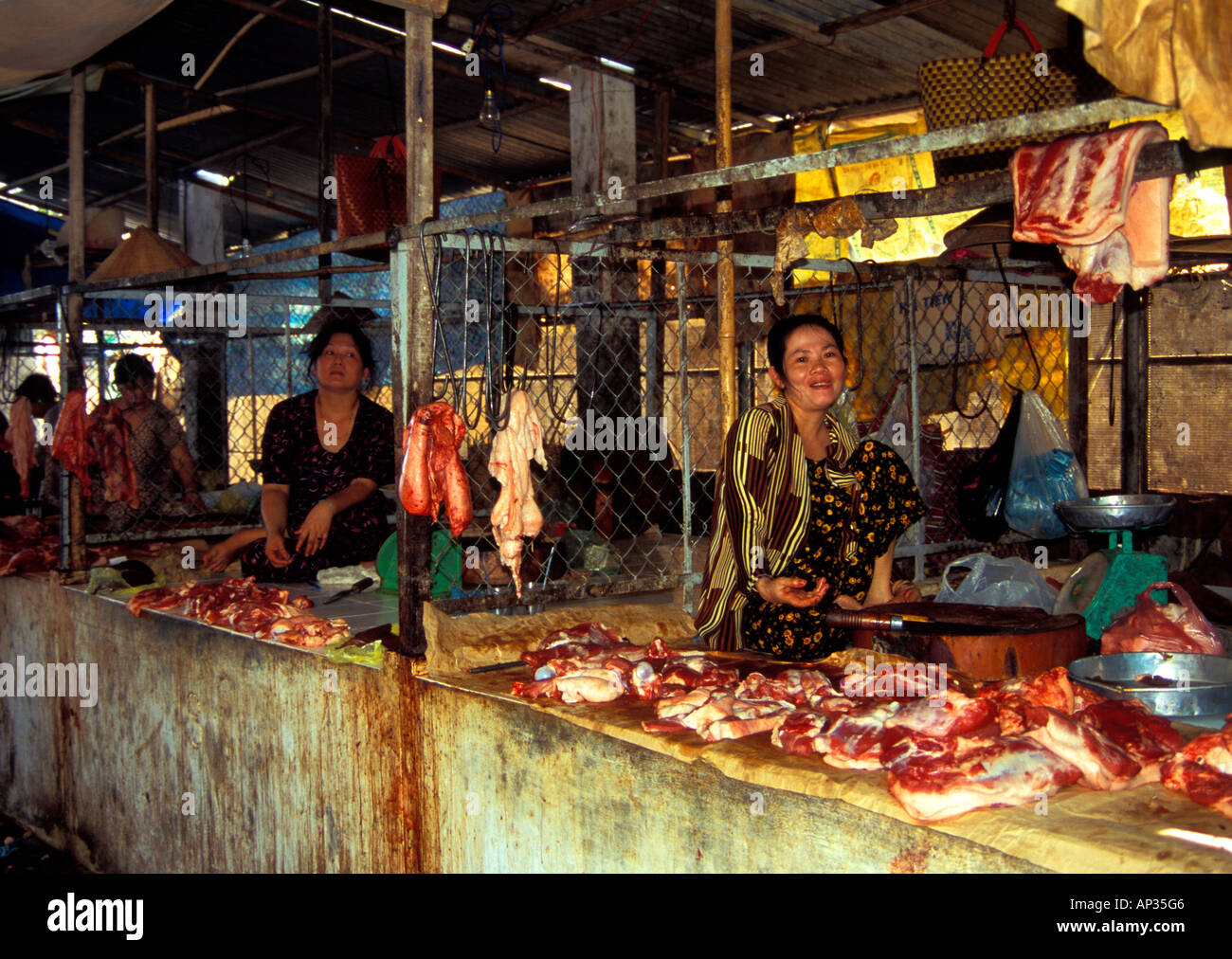 Women selling meat from cages in marketplace, Mekong Delta, South Vietnam Stock Photo