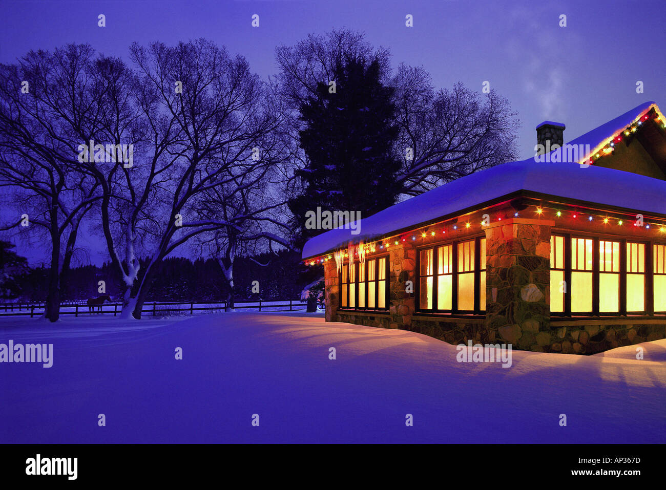 Cottage with Christmas lights in the snow Stock Photo