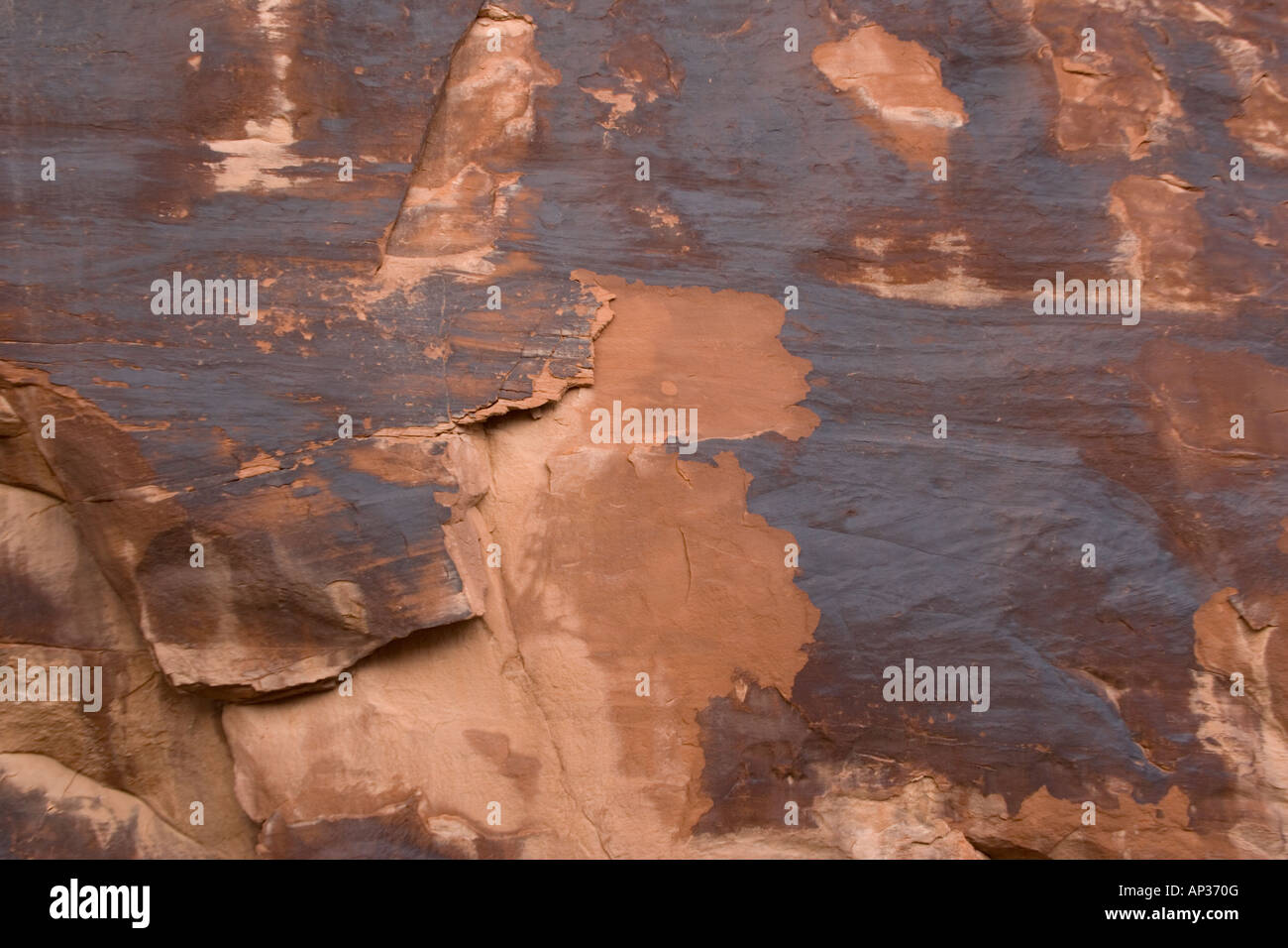 Rock varnish formed on sandstone cliffs over long period by bacterial action including deposition of manganese Stock Photo