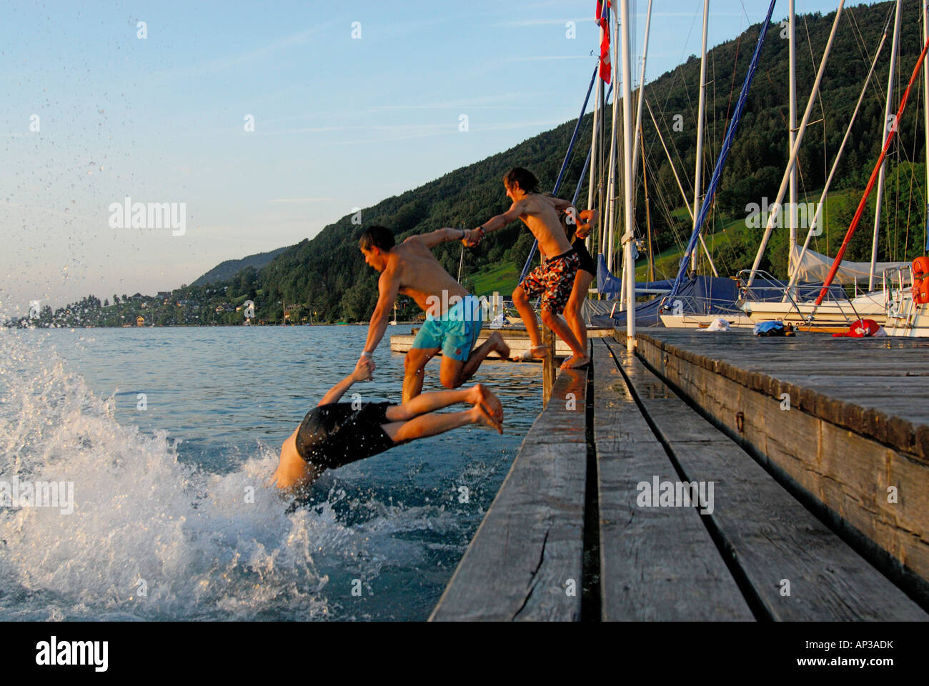 young men diving from landing stage, lake Attersee, Salzkammergut, Salzburg, Austria Stock Photo