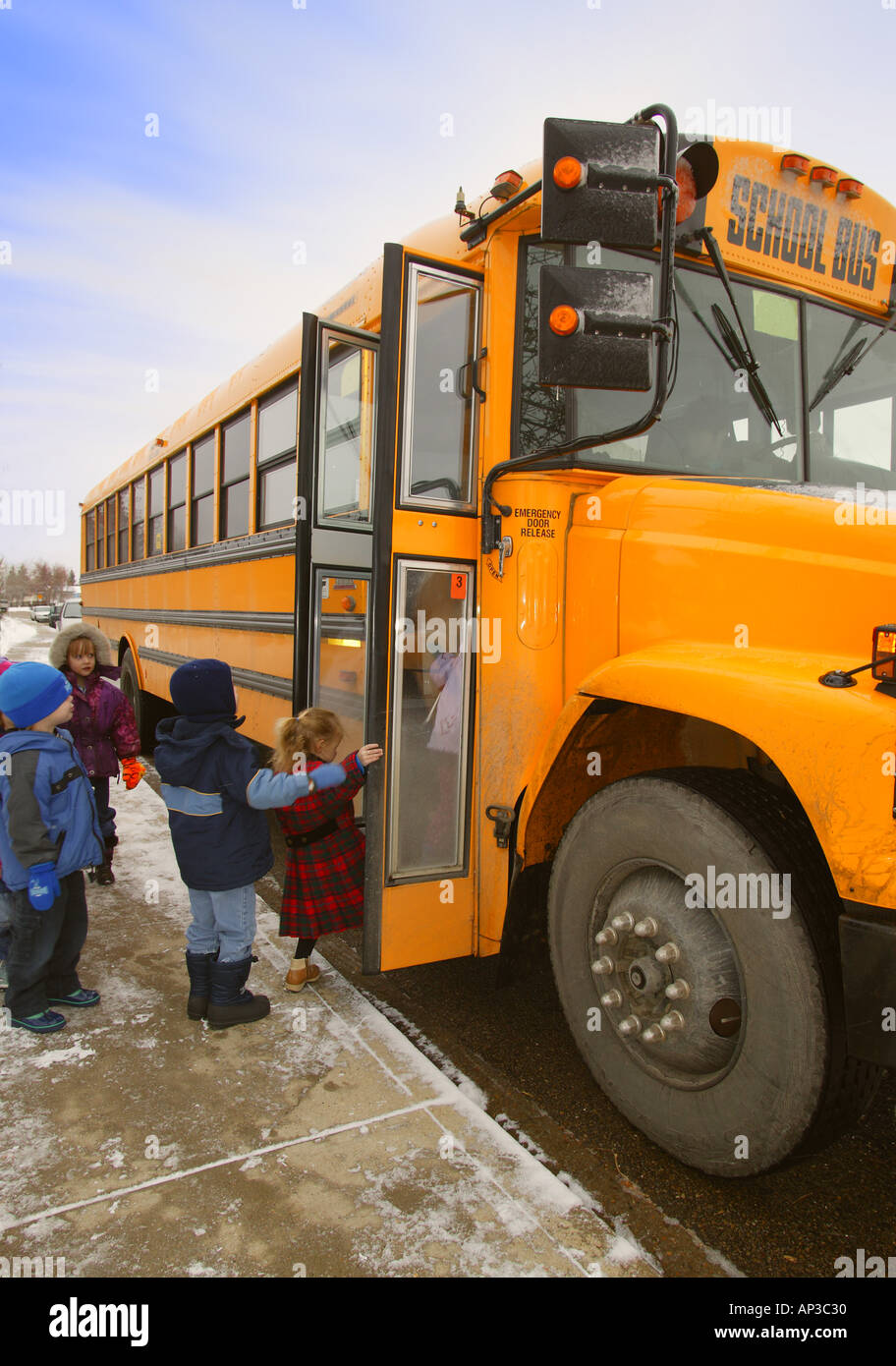 Elementary schoolchildren boarding school bus on a winter day in
