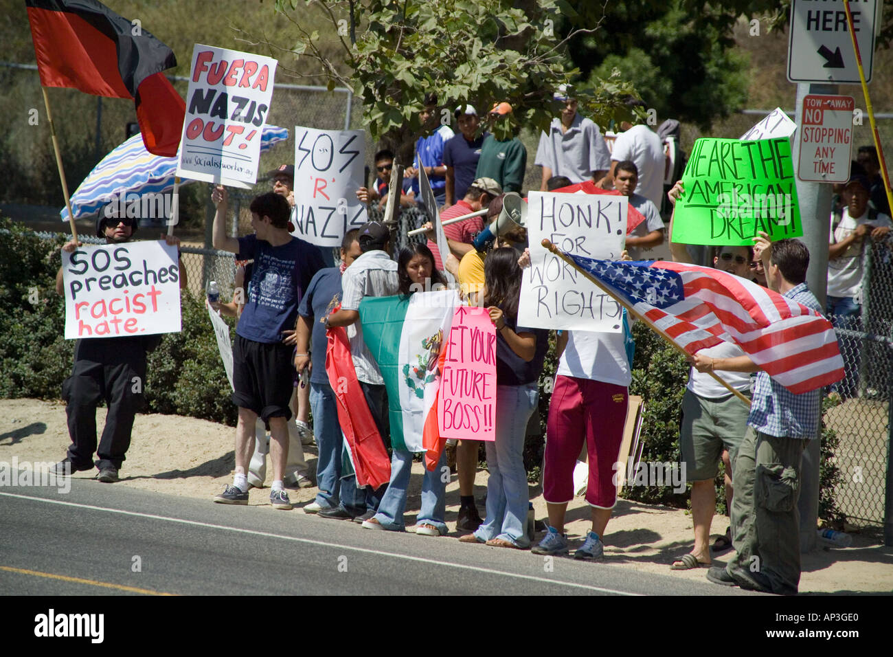 White & Hispanic demonstrators support minority day laborers at a hiring site in Laguna Beach, CA. Stock Photo