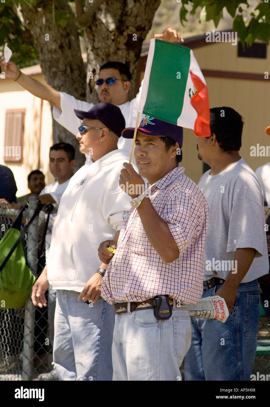 Day laborer waves a small Mexican flag at pro-laborer demonstration in Laguna Beach, CA. Stock Photo
