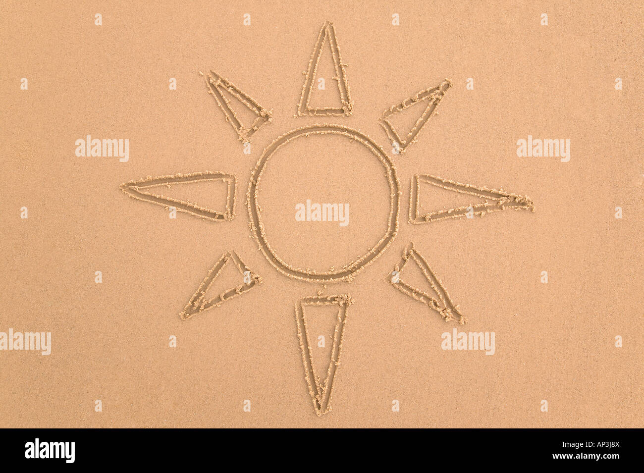 Drawing of the sun done in sand Stock Photo