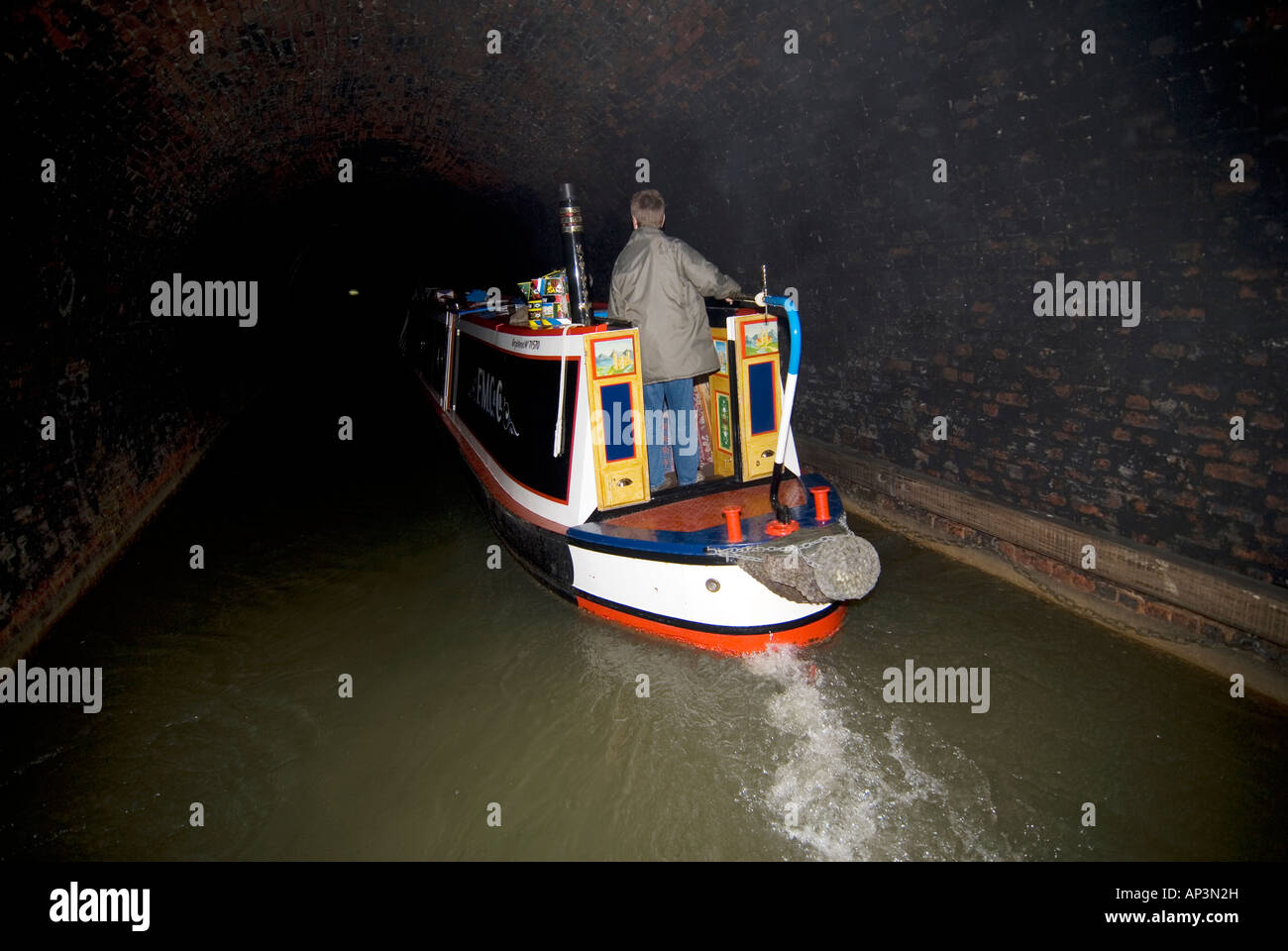 Traditional narrowboat navigating through Blisworth Tunnel on the Grand Union canal Stock Photo