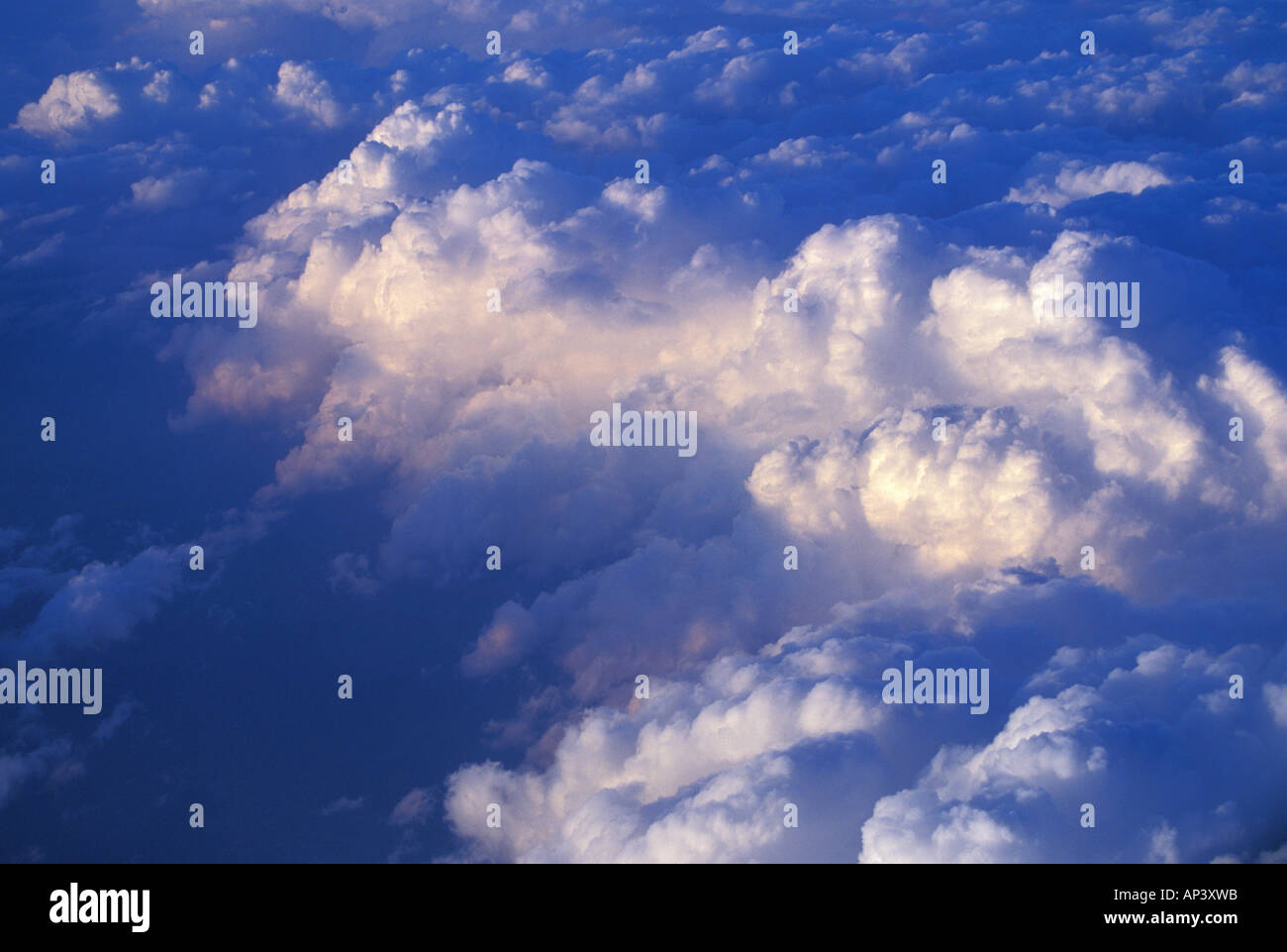 An aerial view of light raking across cumulus clouds, reaching high ...