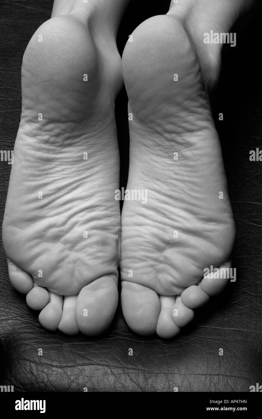 Close Up Close Up Of Womans Foot Soles Bandw On Black Leather Stock