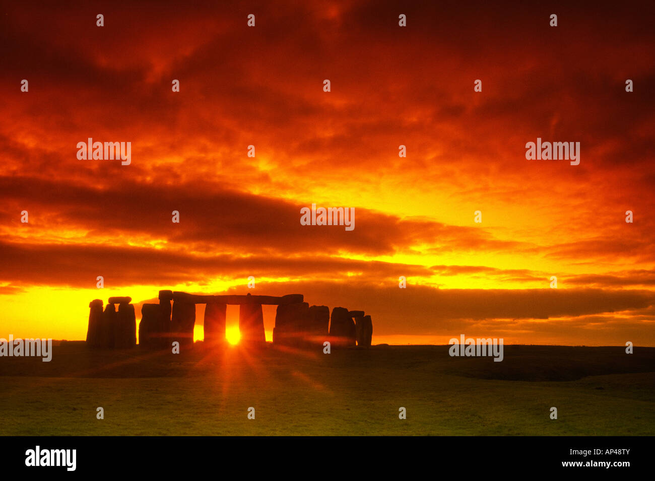 Dramatic view of Stonehenge as the sun rises  with it's rays shing through the standing stones indicating the summer solstice Stock Photo