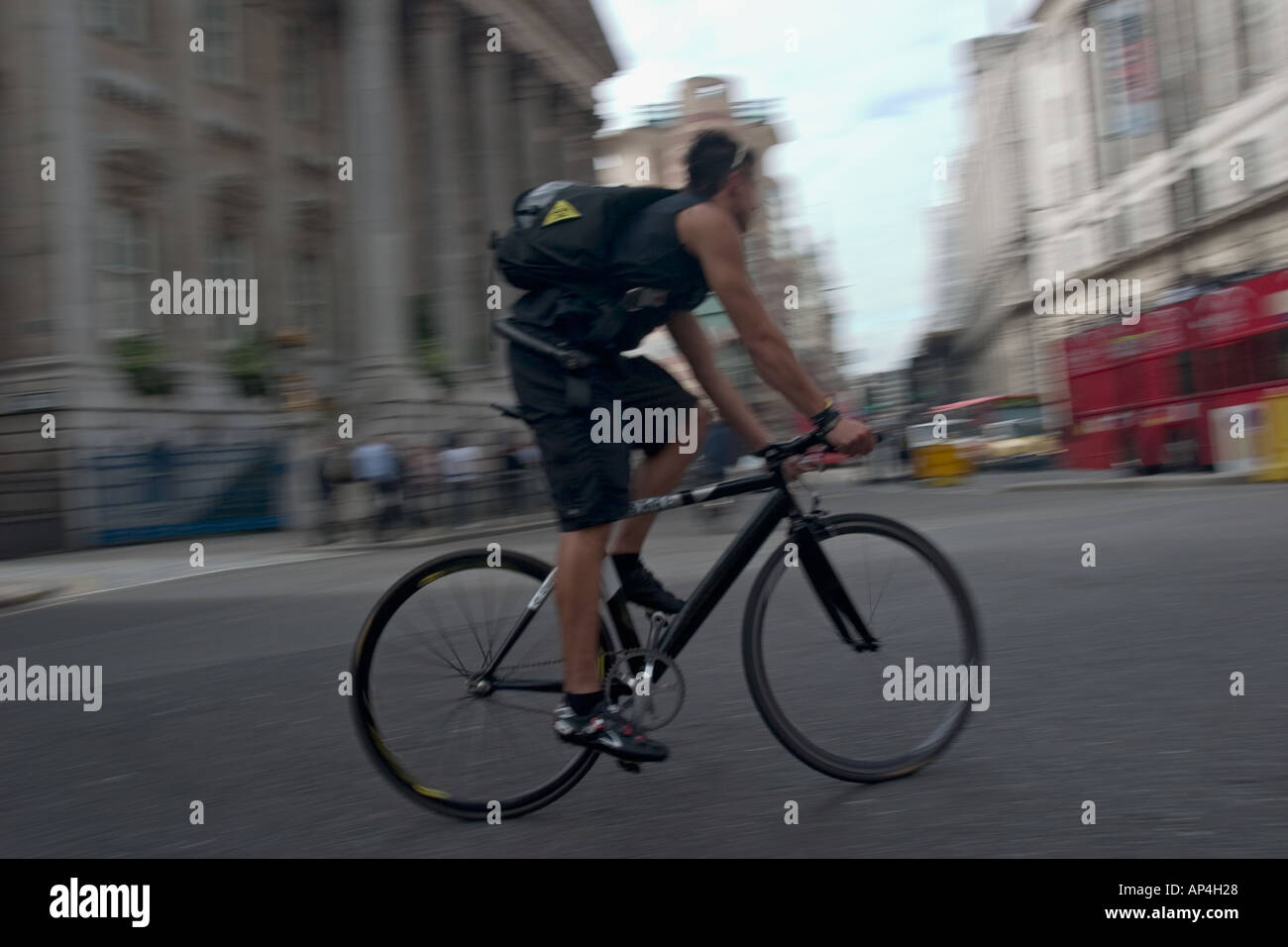 Bicycle courier crosses Bank junction in the heart of London s financial district Stock Photo