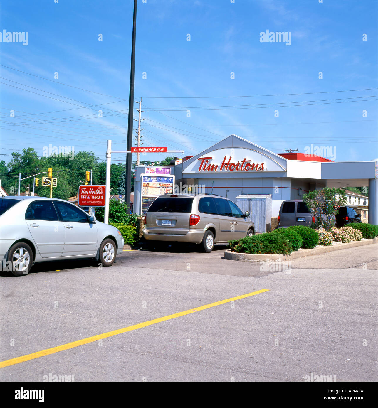 Cars lining up to buy coffee, doughnuts and fast food at Tim Hortons Drive Thru cafe shop store restaurant in Ontario Canada    KATHY DEWITT Stock Photo