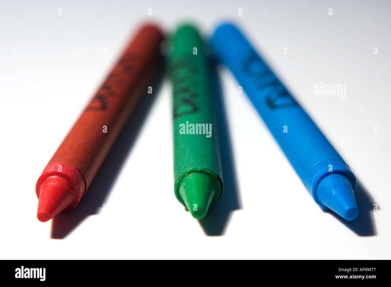 Triple of Red Green and Blue crayons arranged on white background Stock