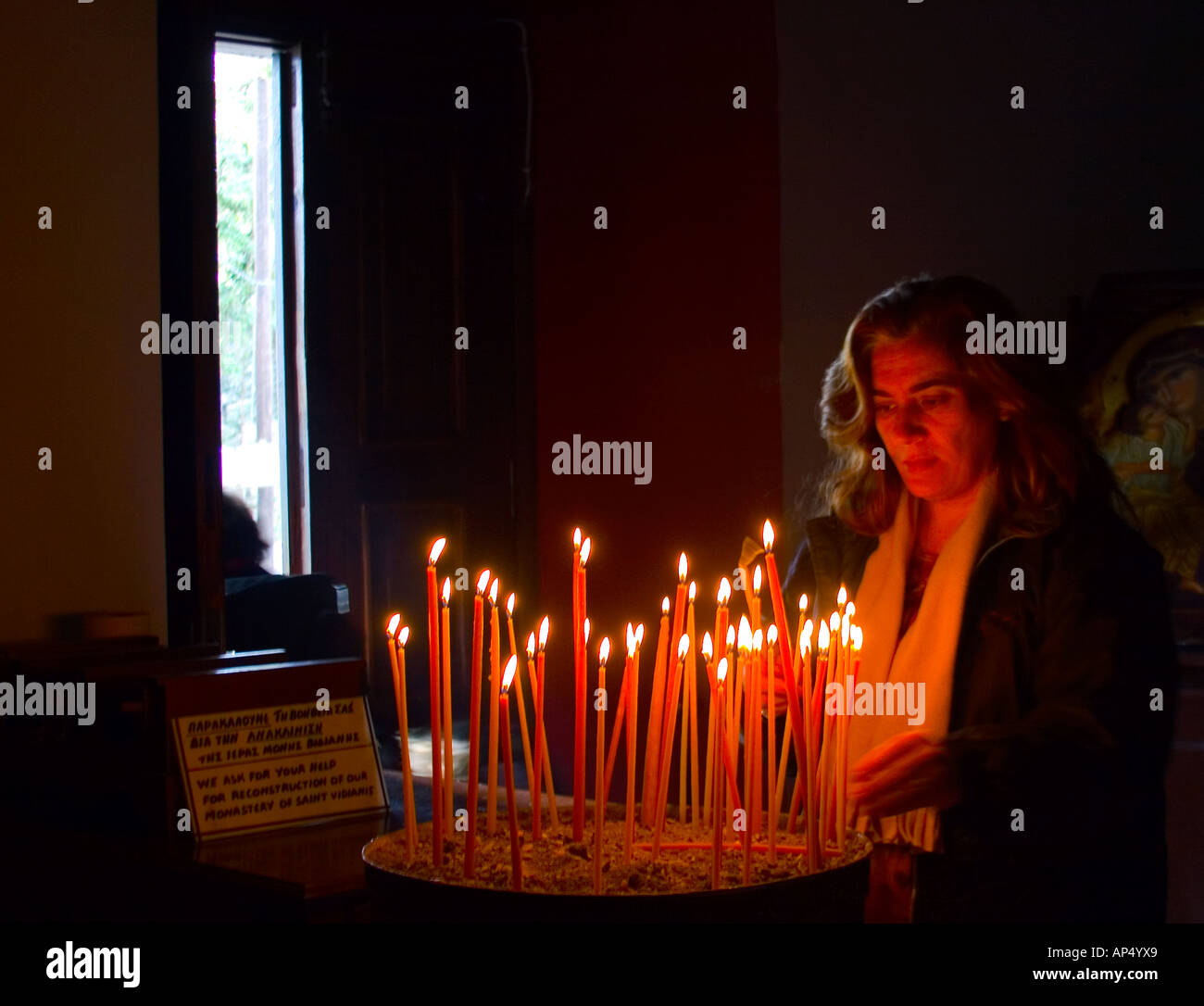 Lady lighting a candle in Greek Orthodox church Stock Photo Alamy