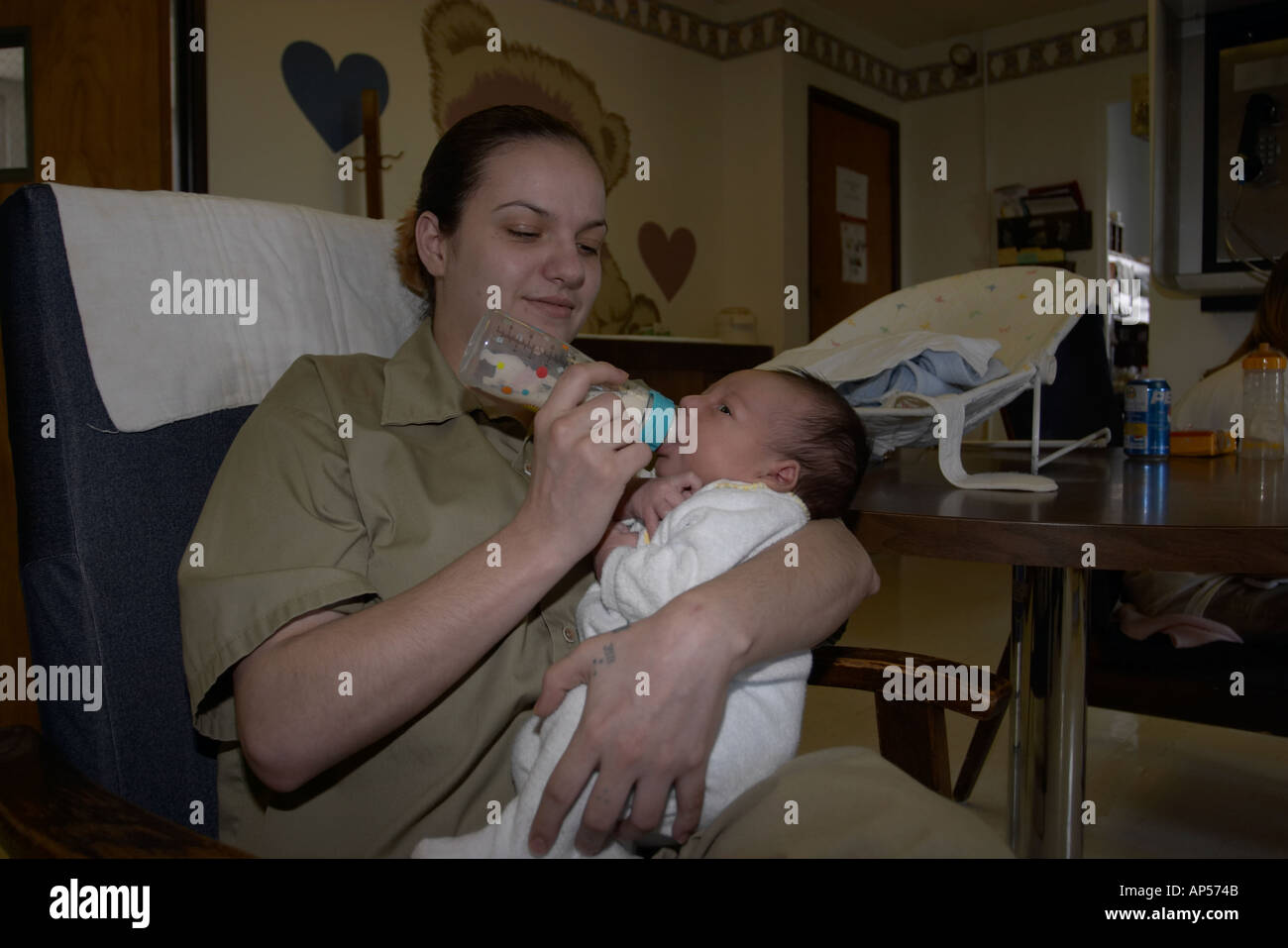 Female inmate feeding her infant son inside prison. Nebraska Correctional Center for Women in York, Nebraska, USA. Stock Photo